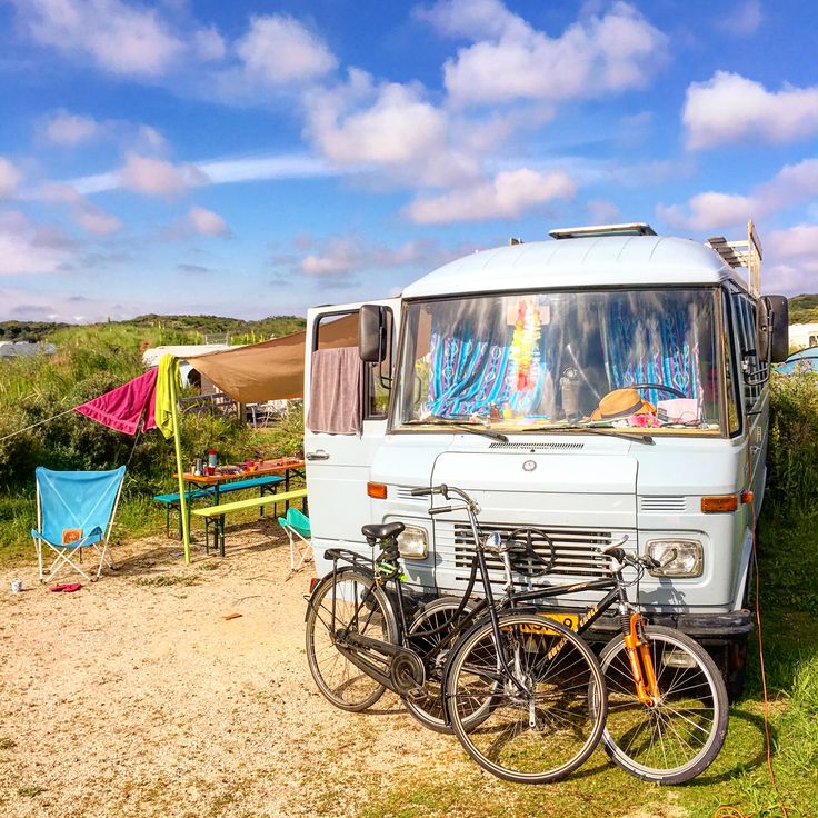Camper met op de neus twee fietsen en een knal bluwe hemel erboven