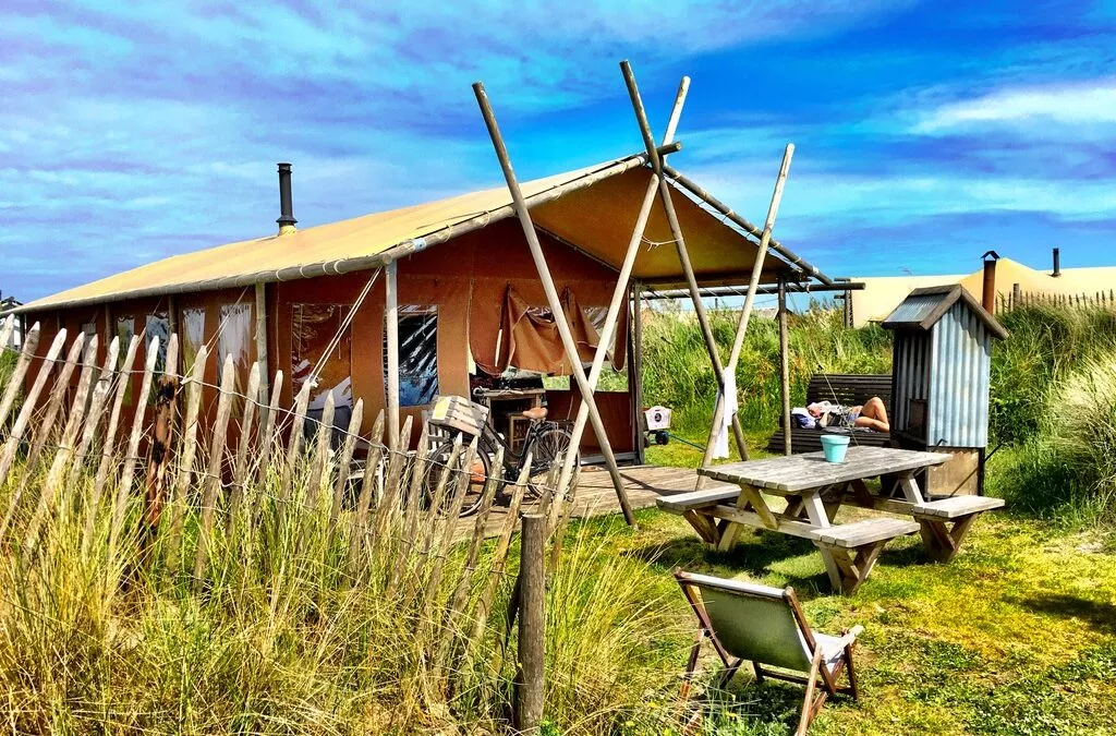 Safari tent in de duinen met een strak blauwe lucht