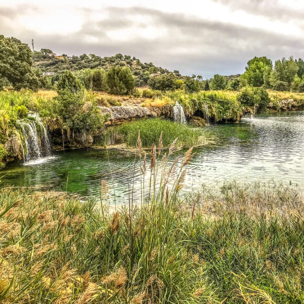 watervalletje bij rivier omzoomd door gras in Spanje