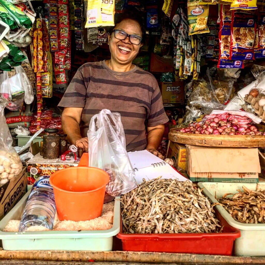 Lachende vrouw in een marktkraam op Bali