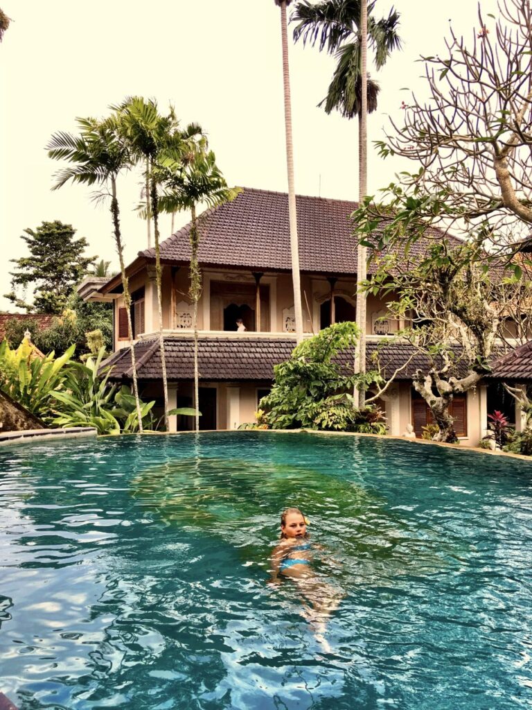 zwembad met een meisje erin met een tropische achtergond