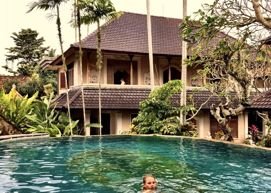 zwembad met een meisje erin met een tropische achtergond
