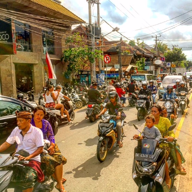 Straat beeld van het brommer verkeer in Ubud