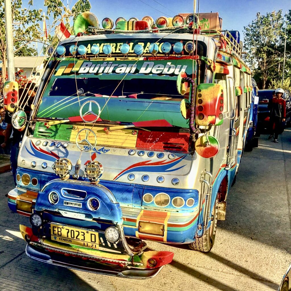 Een kleurijk beschilderde bus op Flores
