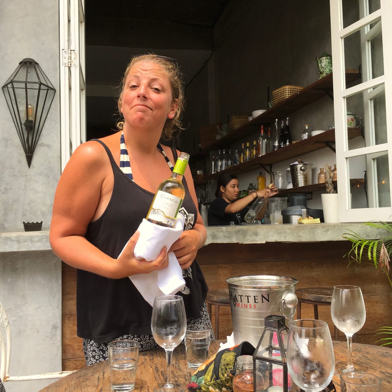 Vrouw met glimlach schenkt een fles wijn uit