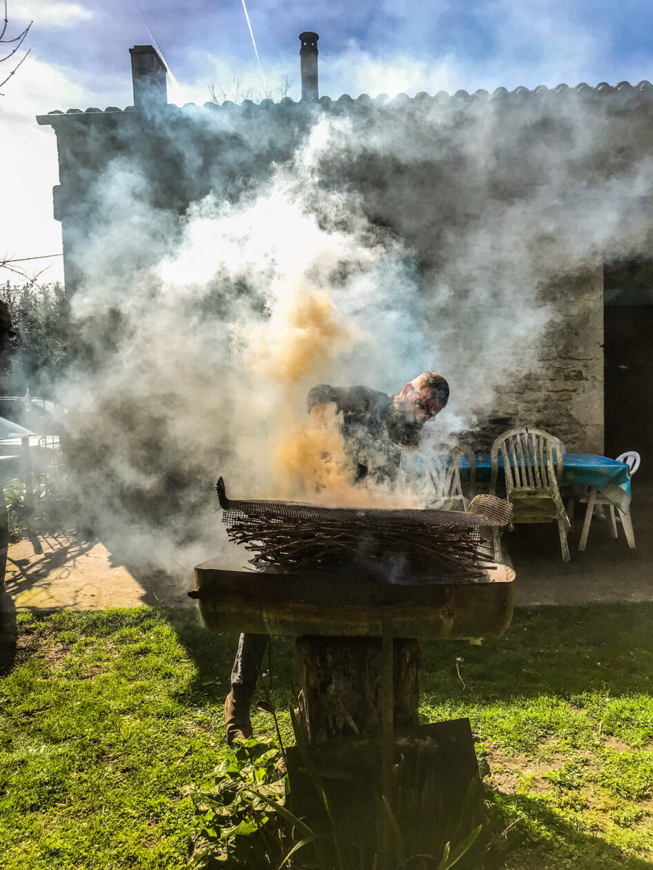 Een man die de bbq aansteekt en verdwijnt in de rook