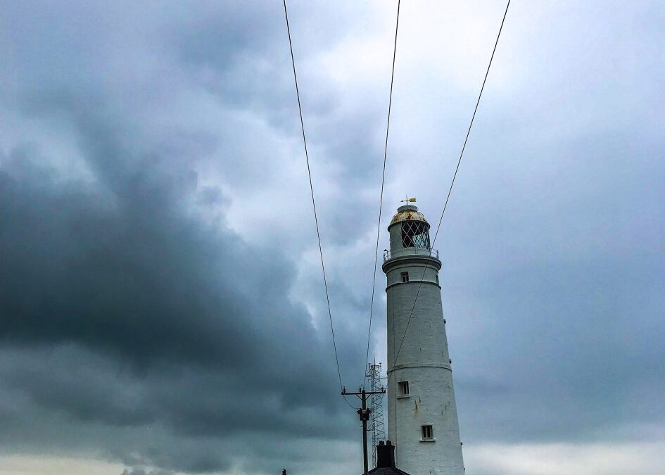 een vuurtoren steekt af tegen de dreigende hemel