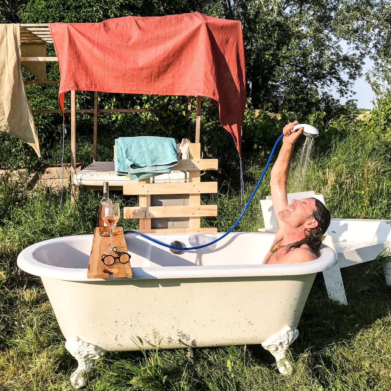 Man in ligbad in een tuin