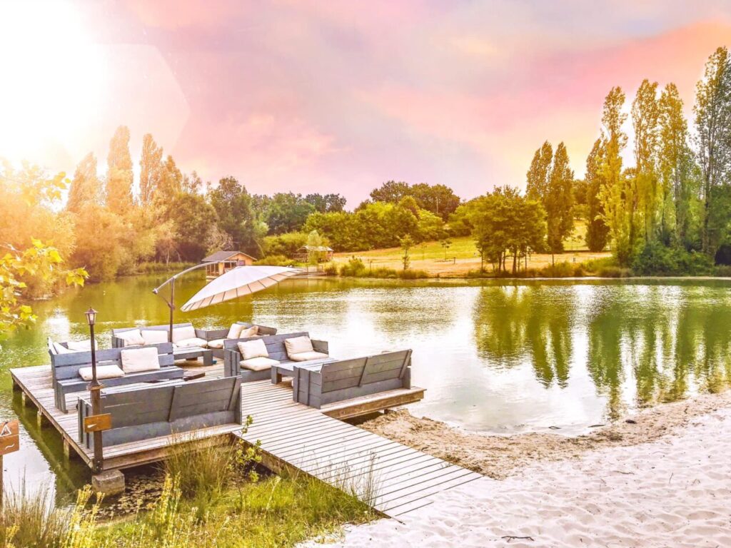 Vlonder in een meertje met bomenrij eromheen en fijn zonnetje