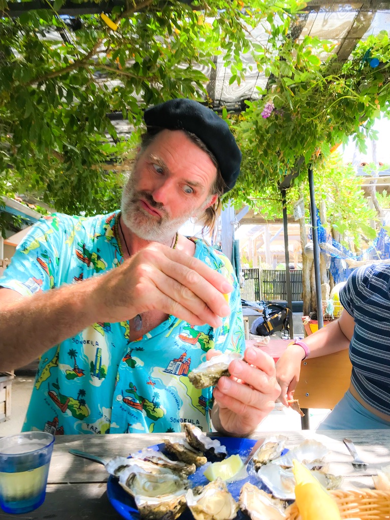 an die citroen uit perst boven een oester met blauw hawai shirt aan