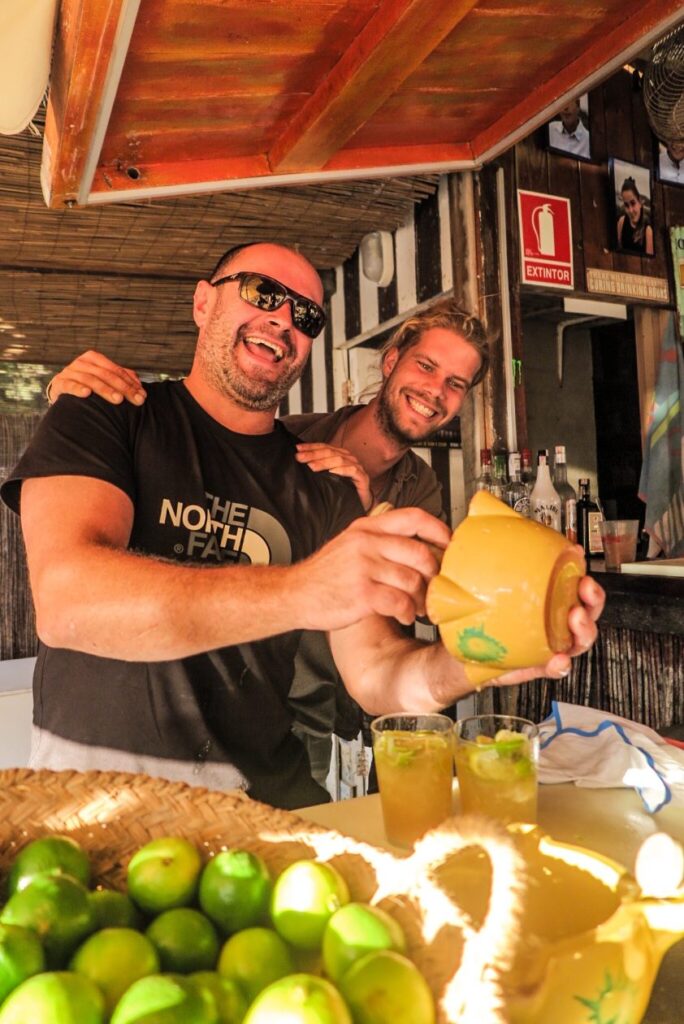 twee blije barkeepers in een cafe met op de voorgrond fruit