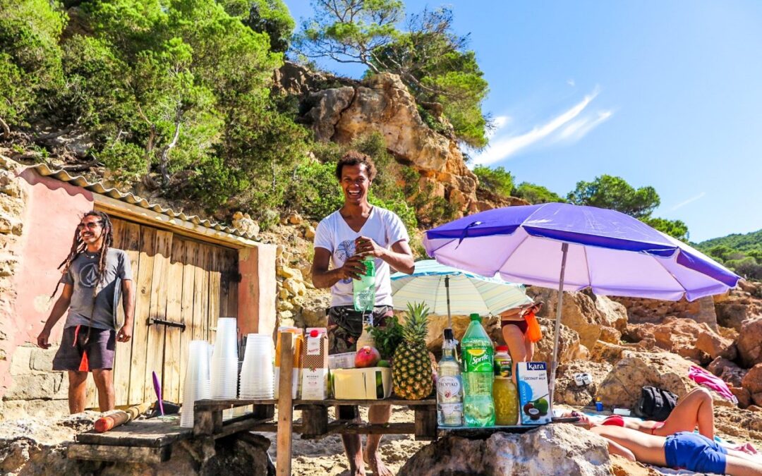 twee mannen die mojito,s verkopen het strand met een paarse parasol