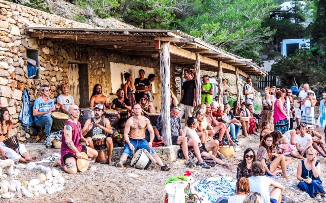 stenen gebouw met afdak van takken met hippie drummers eronder