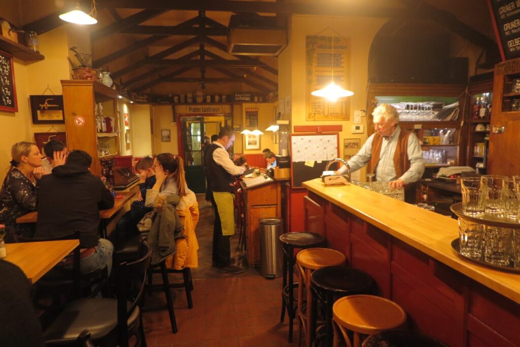 restaurant met rechts een bar met gasten eraan