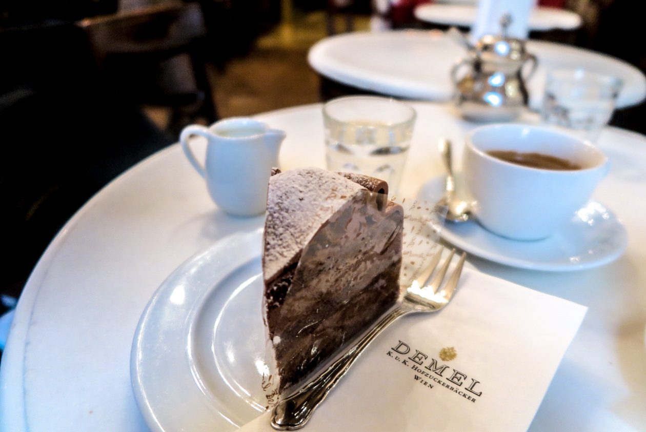 een punt taart en kop kofffie op een elegant gedekt tafeltje