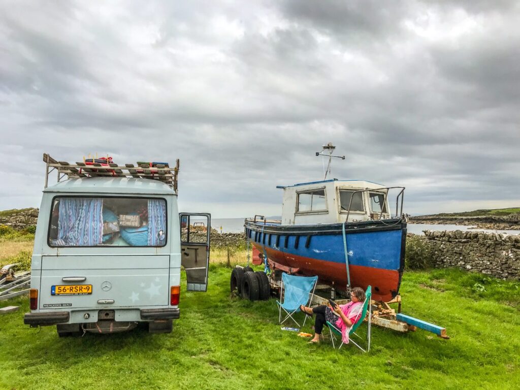 Camper naast een vissersbootje in het gras