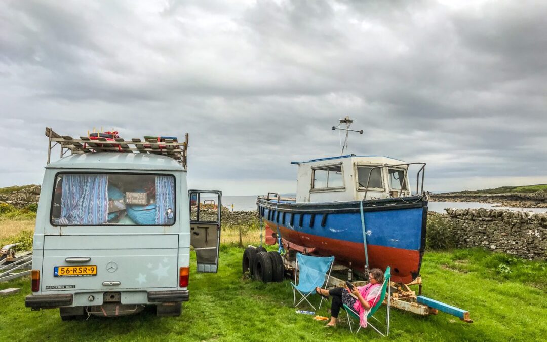 Camper naast een vissersbootje in het gras