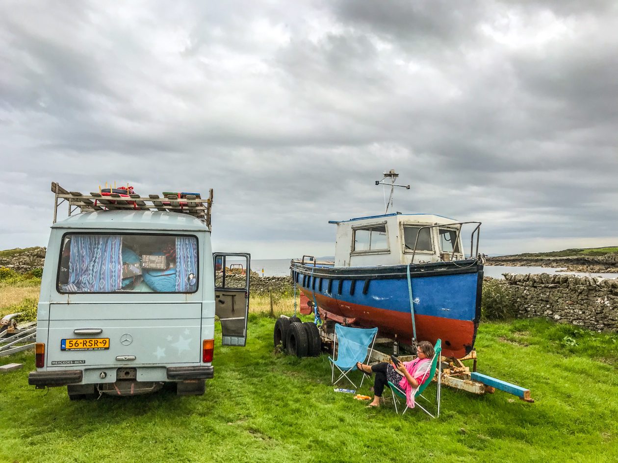 Camper naast een vissersbootje in het gras