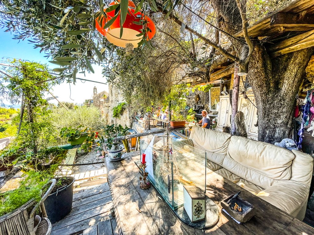 rechts zie je een zelf gemaakte boomhut met links een doorkijkje naar de zee en blauwe hemel