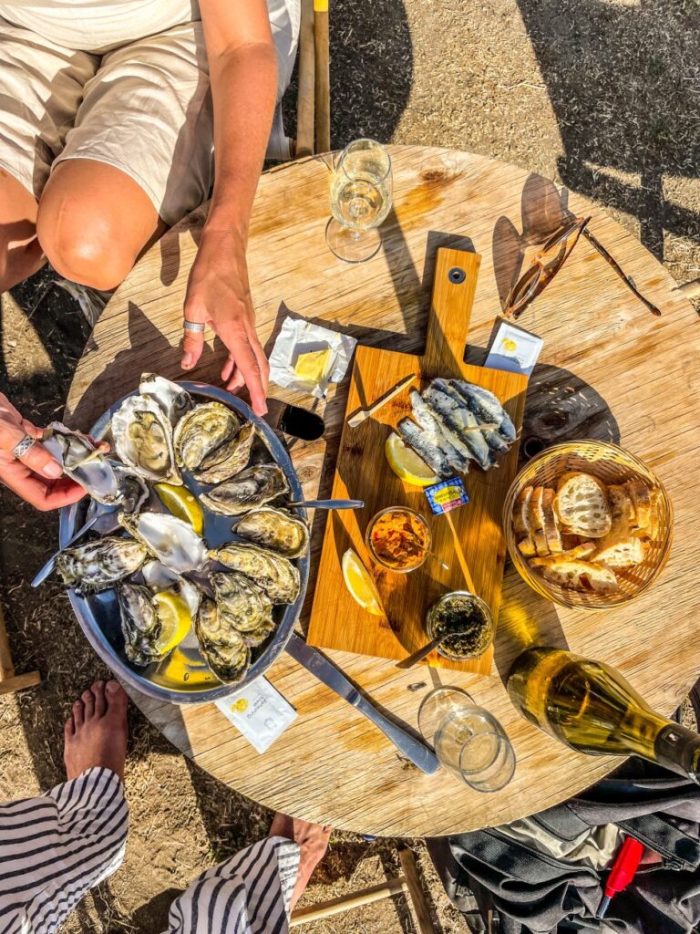 Oesters op een rond houten tafel met twee handen