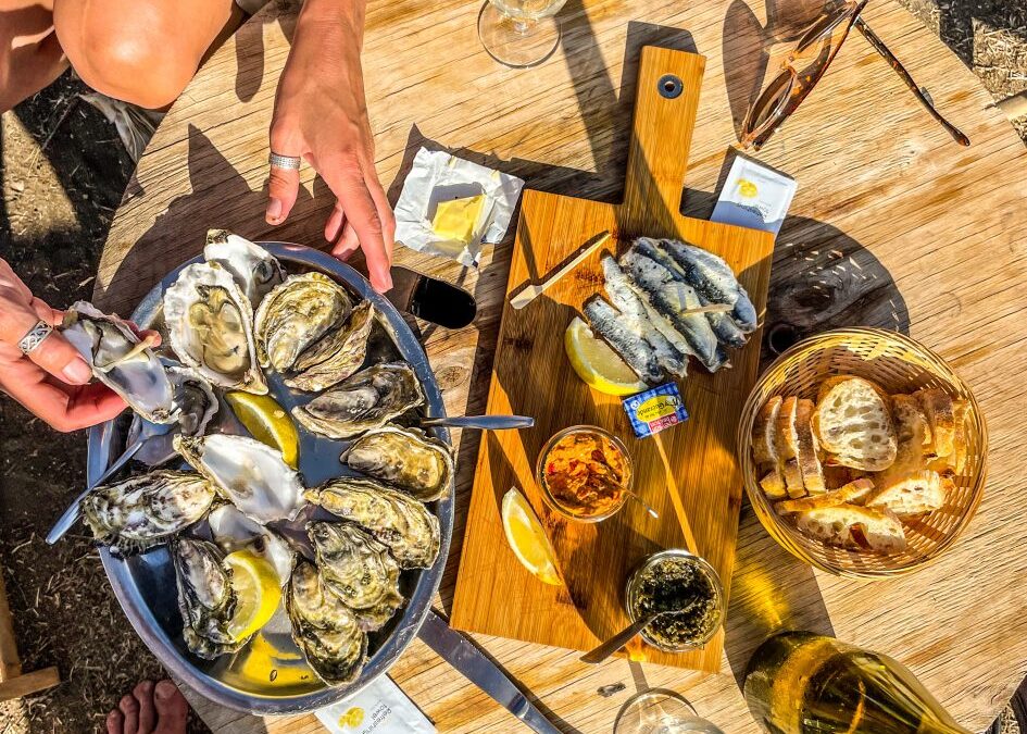 Oesters op een rond houten tafel met twee handen