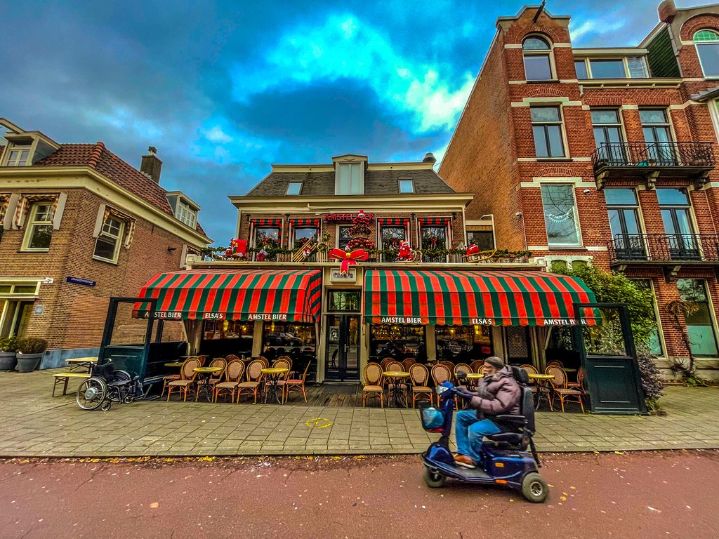 Buiten aanzicht amsterdam's Cafe Elsa's met zwart gestreepte zonnewering