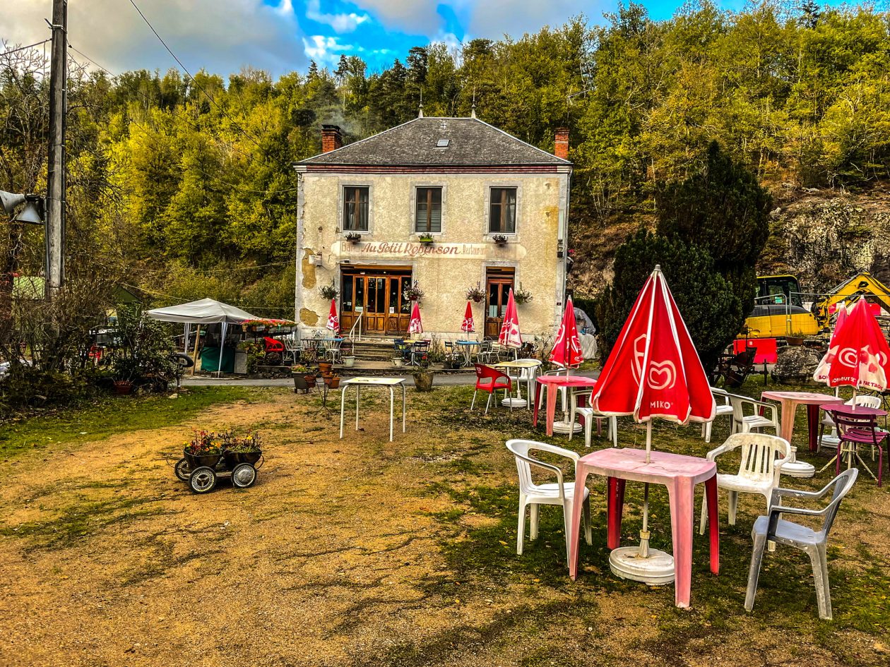 Frans cafe in een bos met op de voorgrond een terras