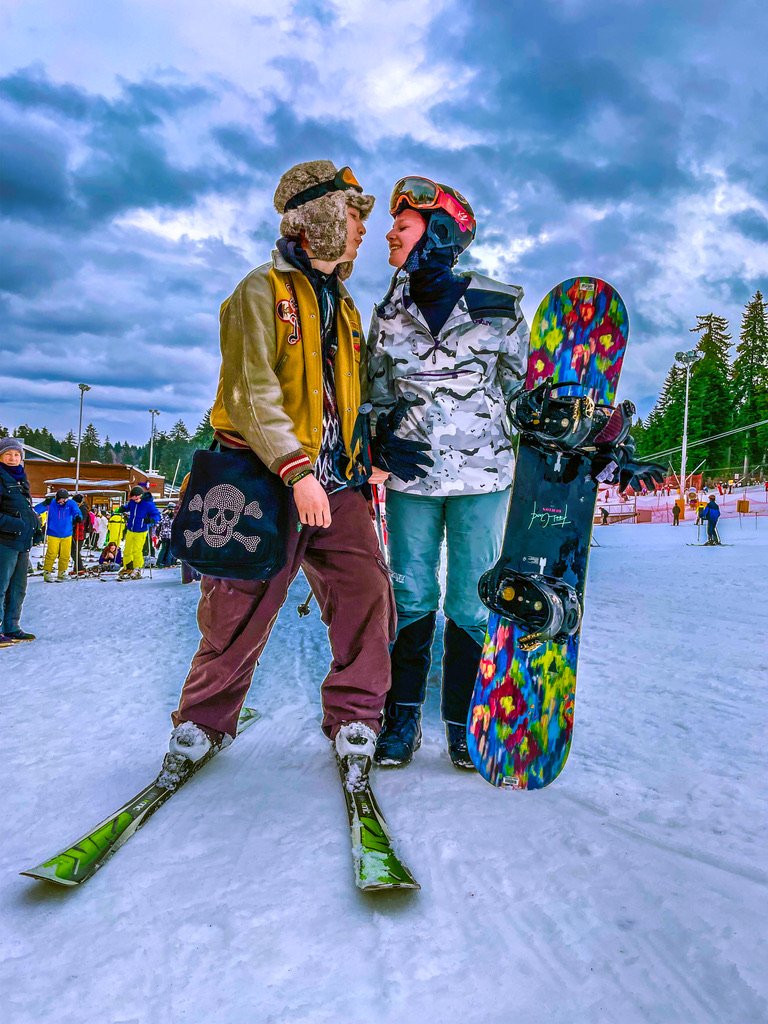 Twee jonge mensen op ski en snowboard in de sneeuw