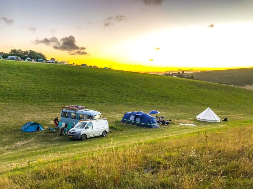 camping met tenten en campers op een glooiend terrein