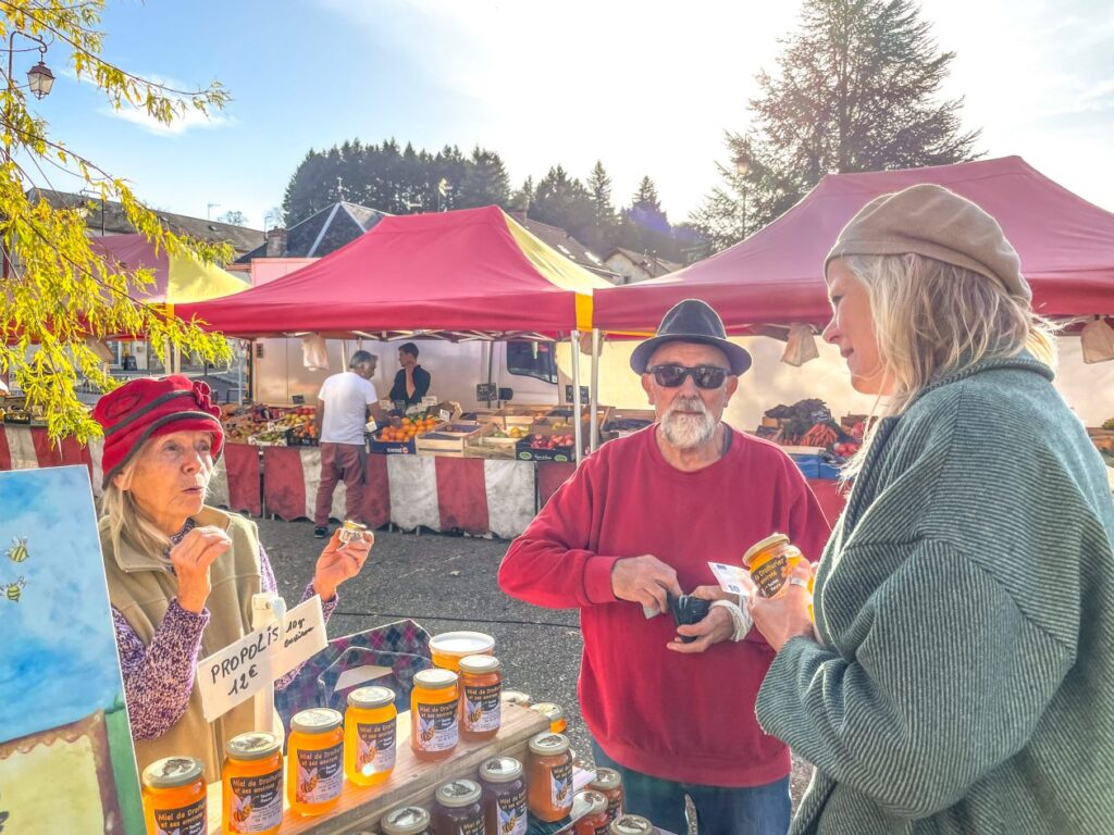 Markt in een Frans dorp - vrouw koopt lokaal gemaakte honing