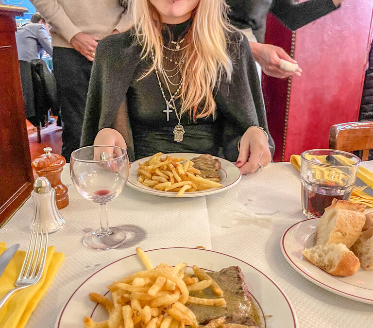 vrouw met ogen wijd open in een frans restaurant