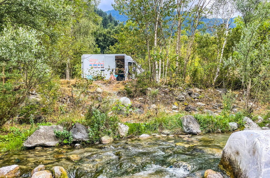 camper in bos aan een rivier