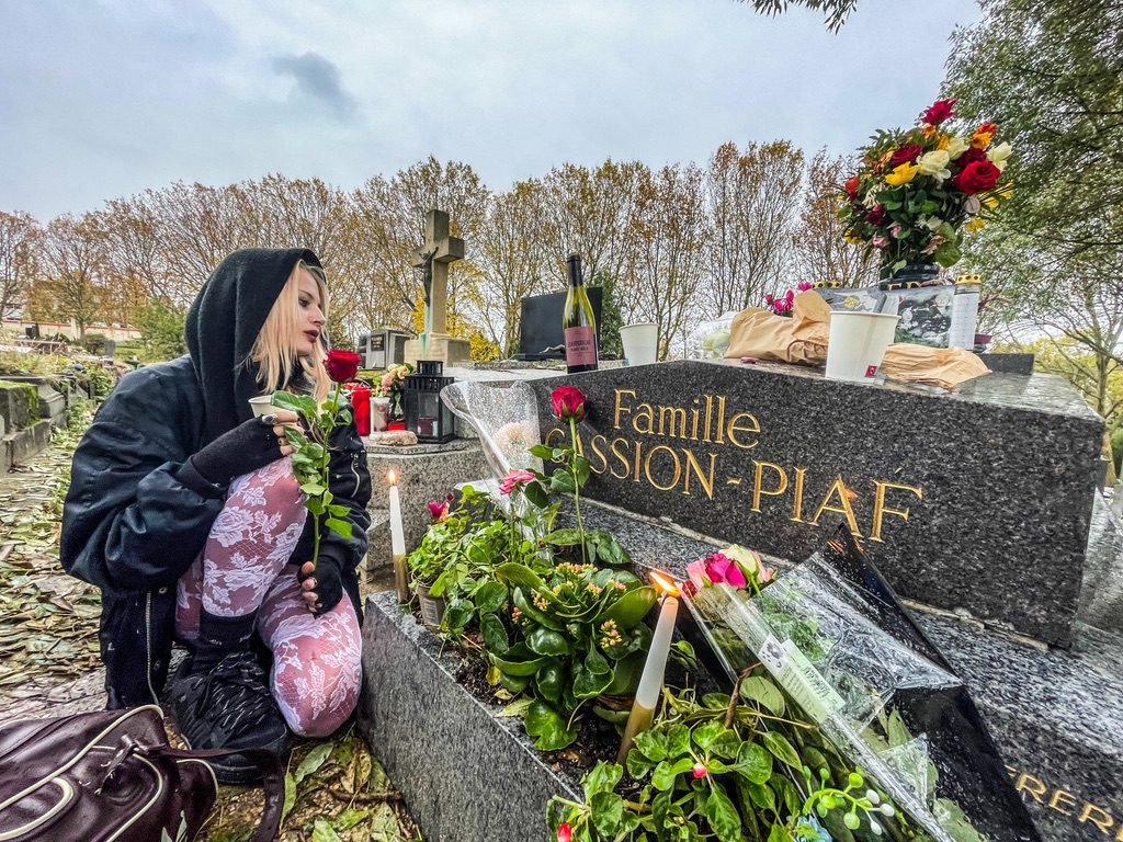 Vrouw zitten voor het graf van Edith Piaf