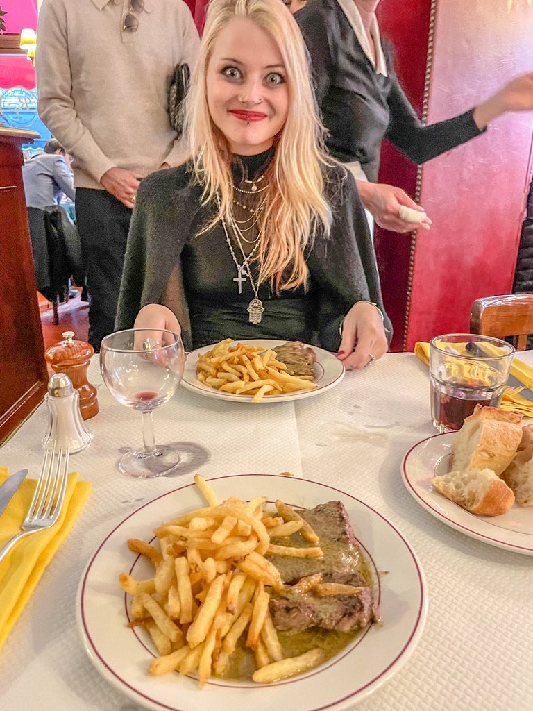 vrouw met ogen wijd open in een frans restaurant