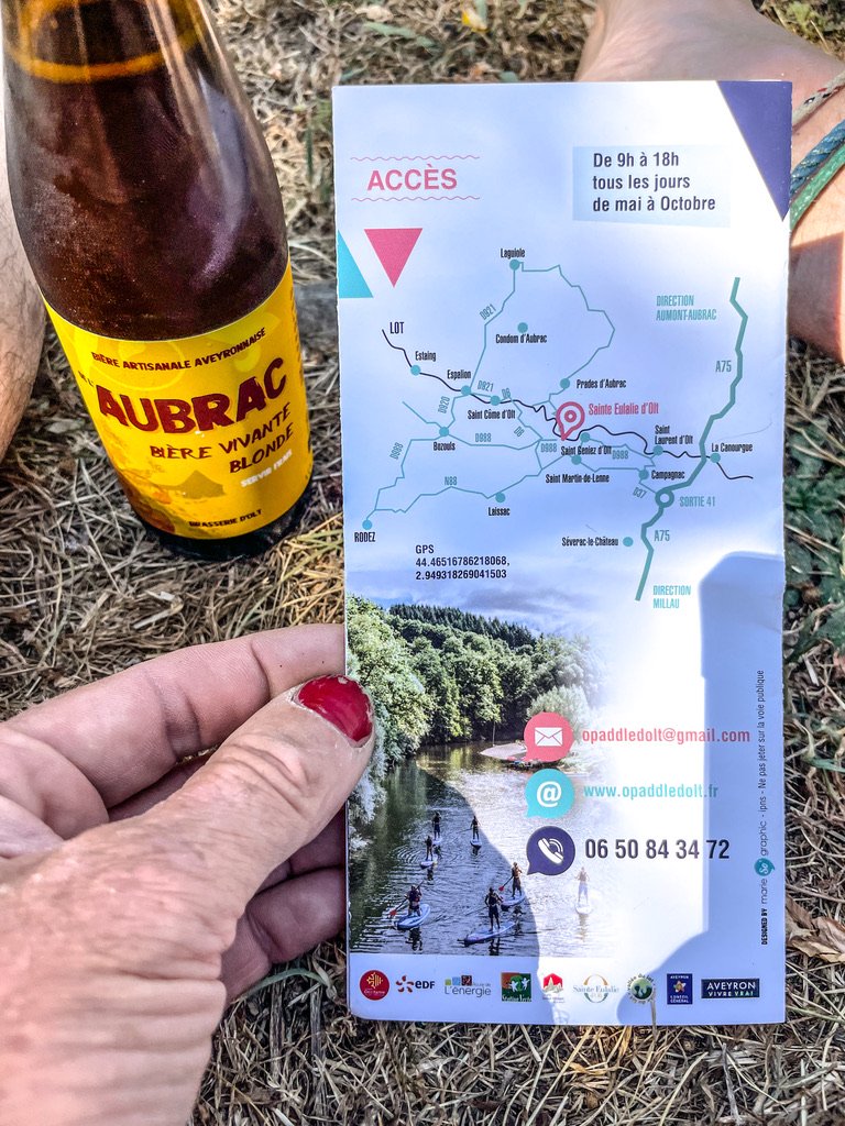 Een hand die een plattegrond vast houd met links een fles Aubrac bier