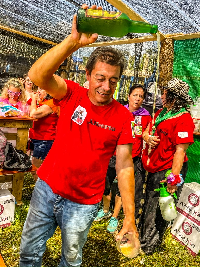 Man in rood t-shirt giet cider in een glas