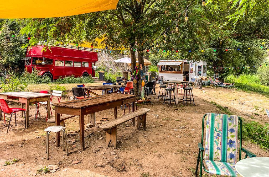 terras met links een engelse dubbeldekker bus