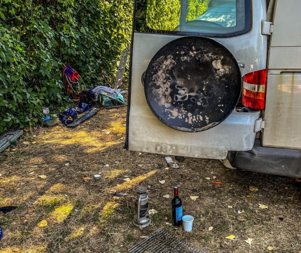 Achterkant van een VW transporter met een vuurschaal aan de achterdeur