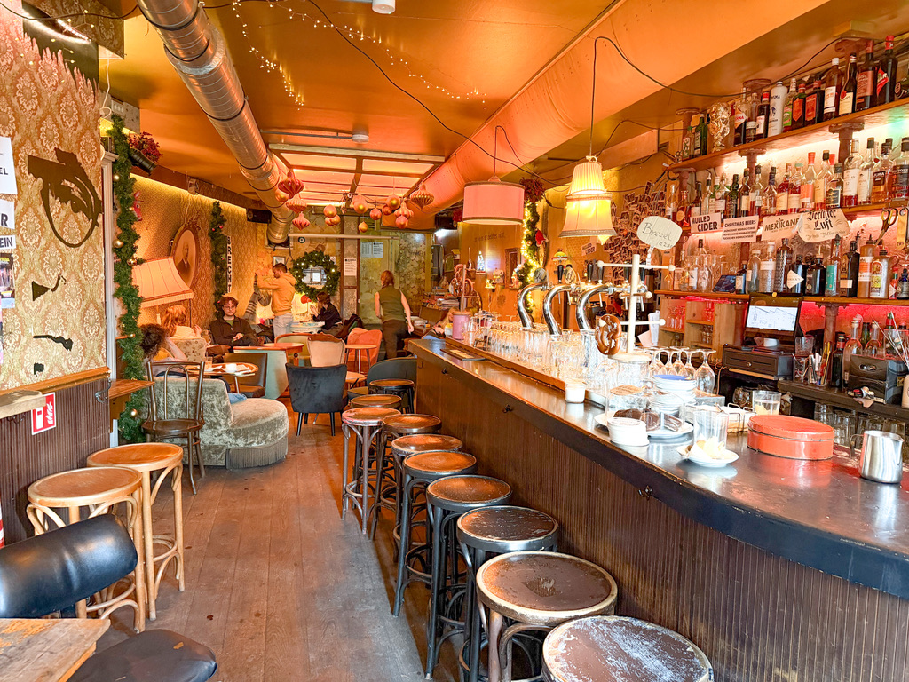 gezellig vintage cafe met rechts de bar en achterin lekker zithoeken