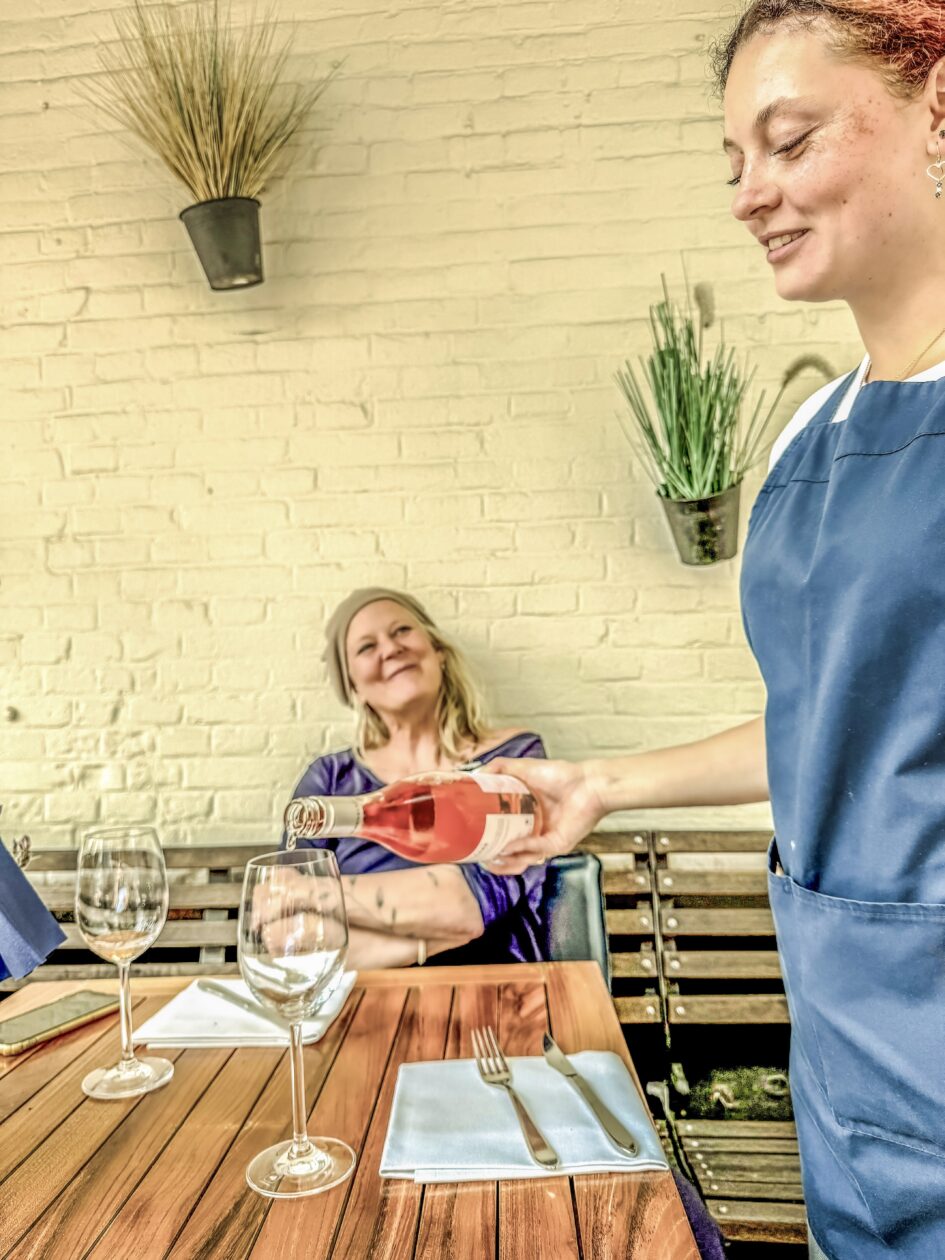 meisje schenkt rose in voor zittende vrouw